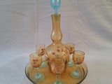 des bouteilles et des verres posés sur un plateau, sur une nappe blanche