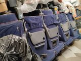 many bags of luggage sitting on the seats of an airplane