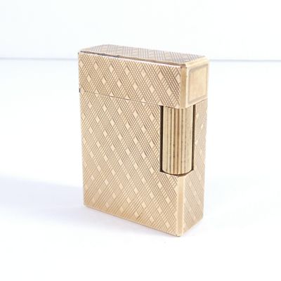 l'image d'un briquet doré posé sur une surface blanche