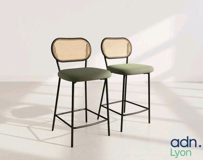 pair of black and green bar stools against a white wall