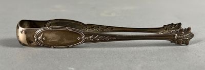an antique spoon with a gold handle sitting on a white surface