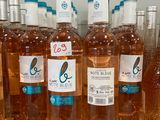 several bottles of rose wine are lined up on a counter