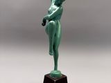 statue en bronze représentant une femme tenant une bouteille d'eau, posée sur un socle