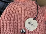 a pink knitted hat with a pom pom on it