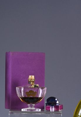 bottles of perfume are sitting on a shelf next to a purple box