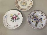 trois assiettes ornées de motifs floraux sont posées sur une table