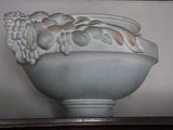 a white vase with a bunch of fruit on it