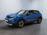 un SUV bleu garé dans une pièce aux murs blancs