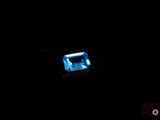 a close up of a blue diamond on a black surface
