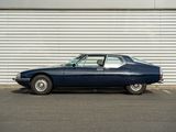 an old blue car parked in front of a garage door