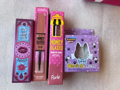 trois boîtes de maquillage posées les unes à côté des autres sur un lit