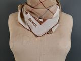beige and red plaid scarf on a mannequin torso