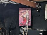 a stage set up for a concert with a large painting on the wall
