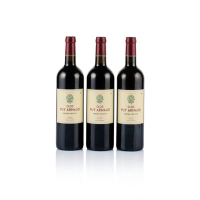 three bottles of red wine sitting next to each other on a white surface