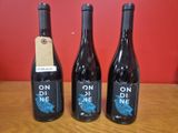trois bouteilles de vin posées sur une table en bois