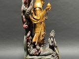 statue of a man holding a bird and a bird on a table