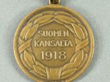 medals are displayed on a white surface with a red, yellow, and blue ribbon
