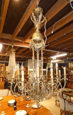 un lustre au milieu d'une pièce où se trouvent de nombreuses tables et chaises