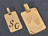 two gold pendants with the initials se and se on them