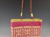 un sac en paille rose et jaune avec une anse marron sur fond gris