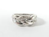 un gros plan d'une bague en argent sertie de diamants sur fond blanc