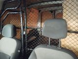 two seats in the back of a vehicle with a fence behind them
