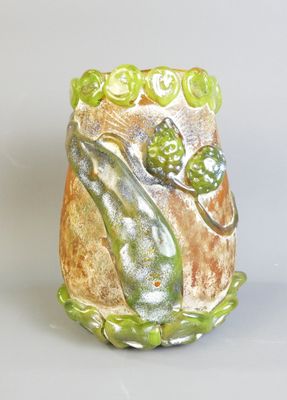 un vase sur lequel est représentée une grenouille et sur lequel se trouve une grenouille