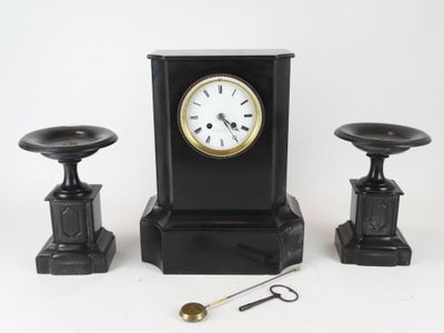 une horloge noire posée à côté de deux tabourets