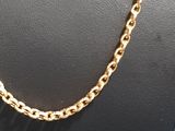 a close up of a gold chain necklace on a mannequin