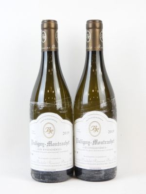 deux bouteilles de vin blanc posées l'une à côté de l'autre sur une surface blanche