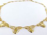 gros plan d'un collier en or sur une surface blanche