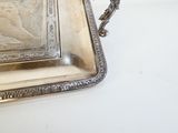 un plateau en argent orné d'une image, posé sur une table