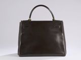 a brown leather handbag sitting on top of a white surface