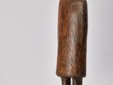 sculpture of a man in a hat and coat standing on a wooden base