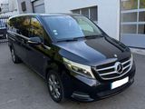 une camionnette noire garée devant un immeuble blanc