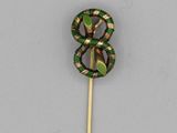 a green and gold pin with a snake on it