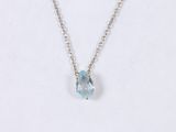 a necklace with a blue topazt stone hangs on a silver chain