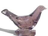 un oiseau en verre posé sur un morceau de bois