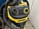 a yellow and black vacuum sitting next to a blue door