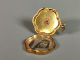 a small gold locke with a picture inside of it