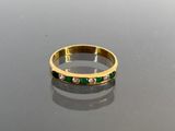 an image of a gold ring with emeralds and diamonds