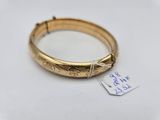 a close up of a gold bracelet with a tag on it
