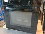 a black oven sitting on top of a pallet in a warehouse