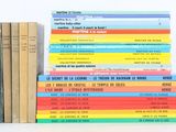 several books stacked on top of each other on a white surface