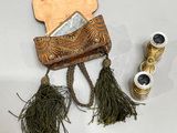 a purse and a pair of binoculars on a table