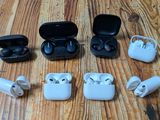 several airpods are lined up on a wooden table with a case