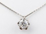 a diamond pendant on a chain on a white surface