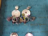 two pairs of earrings sitting on a blue mat