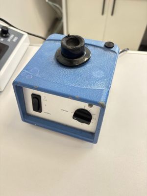 un petit objet bleu posé sur une table à côté d'un ordinateur portable