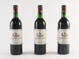 trois bouteilles de vin rouge sont alignées sur une surface blanche